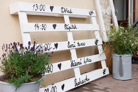 Detail na dřevěnou paletu se svatebním programem