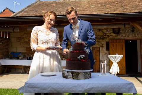Nevěsta se ženichem zakrajují dort