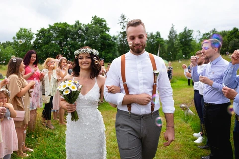 Nevěsta se ženichem jdou špalírem