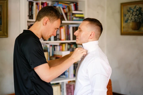 Bratr nasazuje ženichovi motýlka