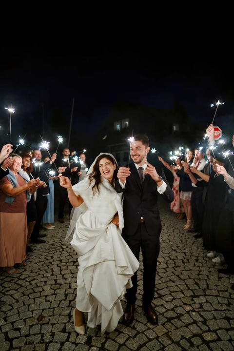 Nevěsta se ženichem jdou špalírem a drží prskavky