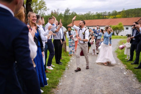 Ženich se raduje a plácá si se svatebčany rukou, farma Heroutice.