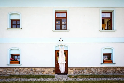 Šaty nevěsty visí na dveřích Stanského mlýna
