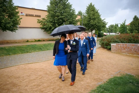Ženich s maminkou jdou k místu obřadu, Štábní domek