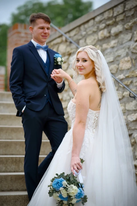 Ženich drží nevěstu za ruku na schodech před Chrámem sv. Báry, Kutná Hora