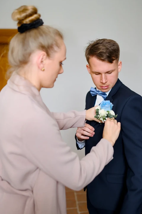 Ženich si nasazuje korsáž