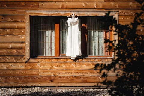 Šaty nevěsty visí na okně, svatba Golf resort Kunětická hora