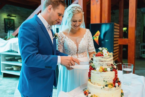 Nevěsta se ženichem zakrajují dort, svatba Golf resort Kunětická hora