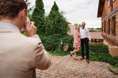 Muž fotí instantním fotoaparátem mladý pár, svatba Golf resort Kunětická hora