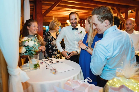 Svatební hosté se smějí nad fotoknihou, svatba Golf resort Kunětická hora