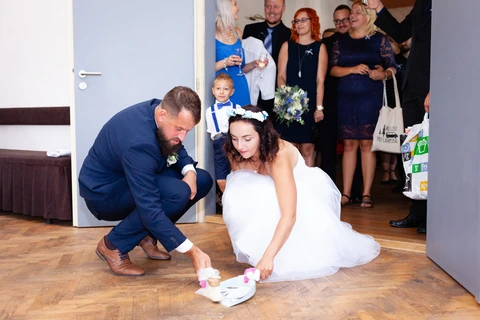 Nevěsta se ženichem zametají střepy