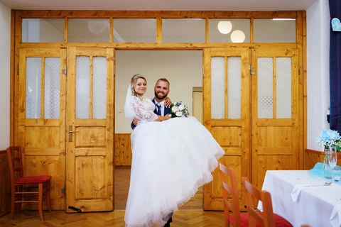 Ženich přenáší nevěstu přes práh