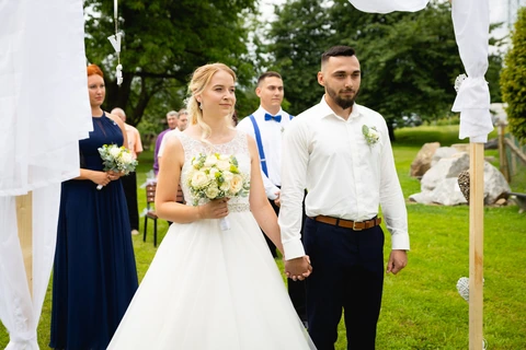 Detail nevěsty a ženicha, jak stojí při obřadu