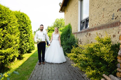 Nevěsta se ženichem jdou podél restaurace