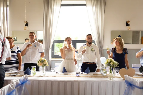 Přípitek nevěsty a ženicha v restauraci