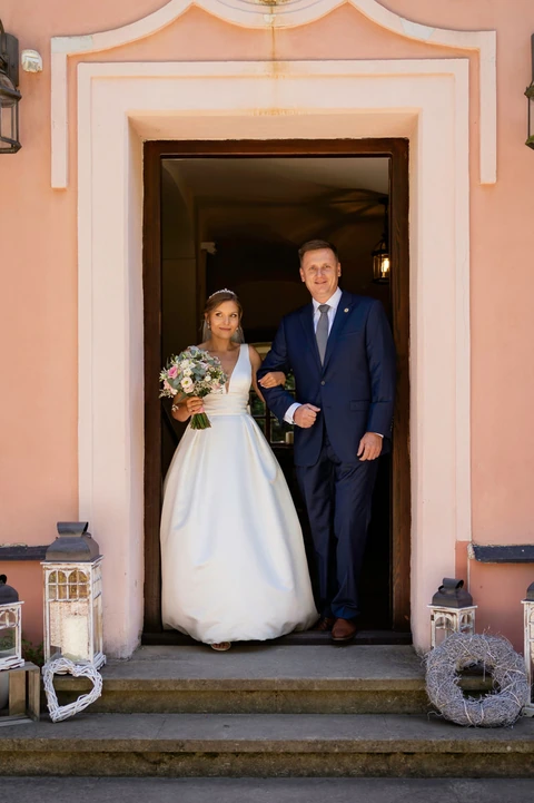 Tatínek s nevěstou stojí ve dveřích zámečku Klokočov