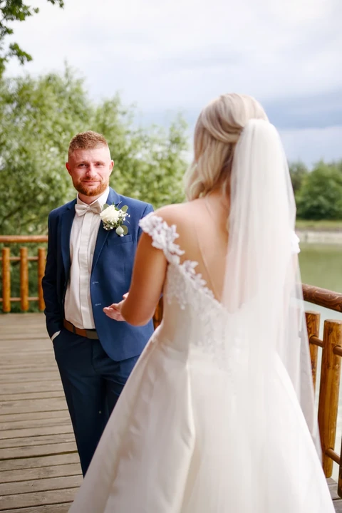 Ženich kouká na fotografa přes nevěstu, svatba Lhota pod Libčany