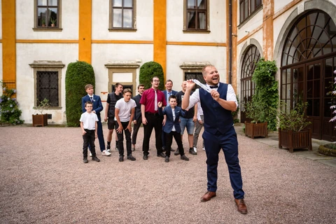 Ženich se směje a chystá se vystřelit podvazek nevěsty, zámek Choltice