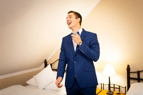 Ženich se směje a stříká si parfém na krk