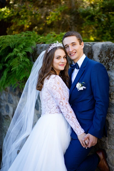 Svatební portrét, nevěsta se ženichem jsou u sebe a smějí se na fotografa
