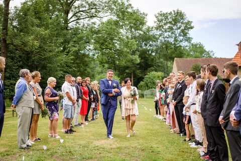 Maminka vede ženicha k místu obřadu