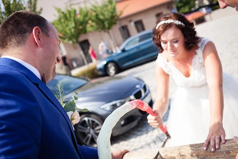 Nevěsta se ženichem řežou kládu