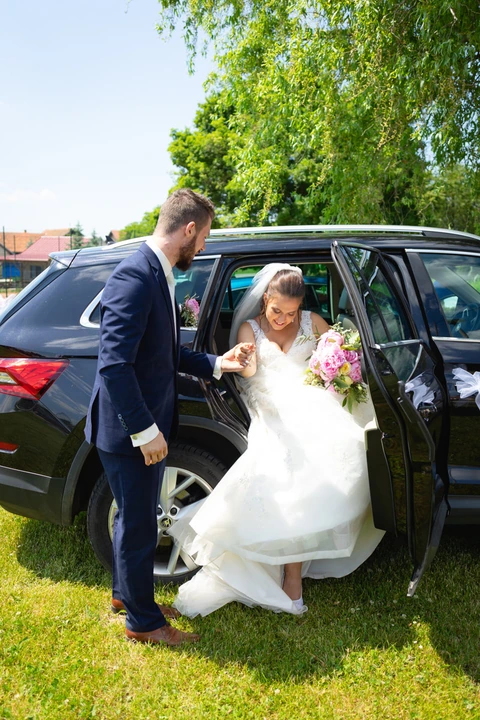 Ženich pomáhá nevěstě z auta