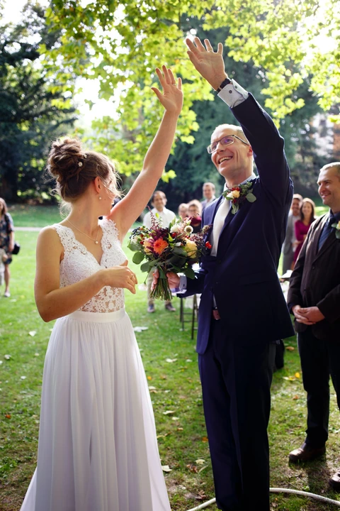 Nevěsta se ženichem ukazují svatebčanům prstýnky
